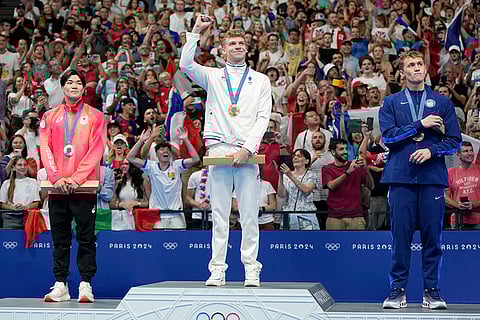 Gold medalist Leon Marchand stands with Tomoyuki Matsushita (silver) left, and Carson Foster (bronze)